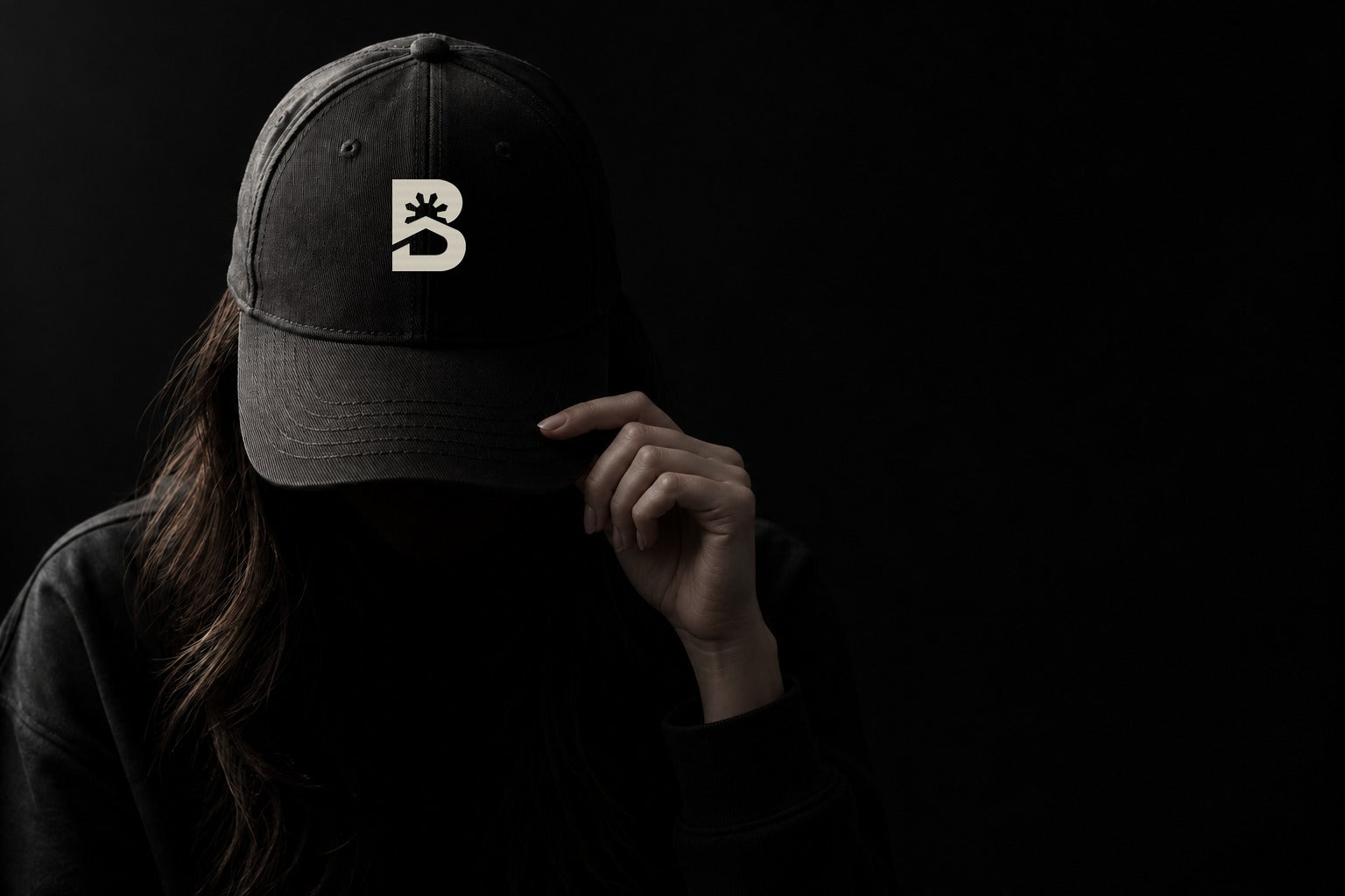 AI-generated campaign portrait of a woman with her face hidden beneath a black cap bearing the original BRGY.HOOD icon.